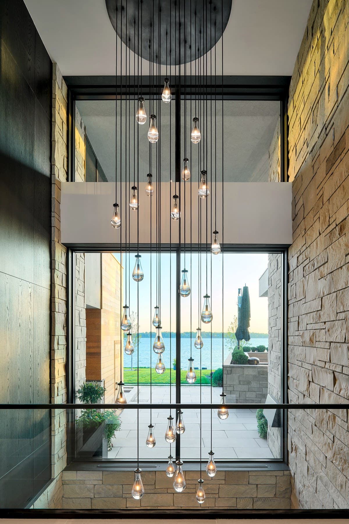 Cascading pendant chandelier with lake view — curated lighting design