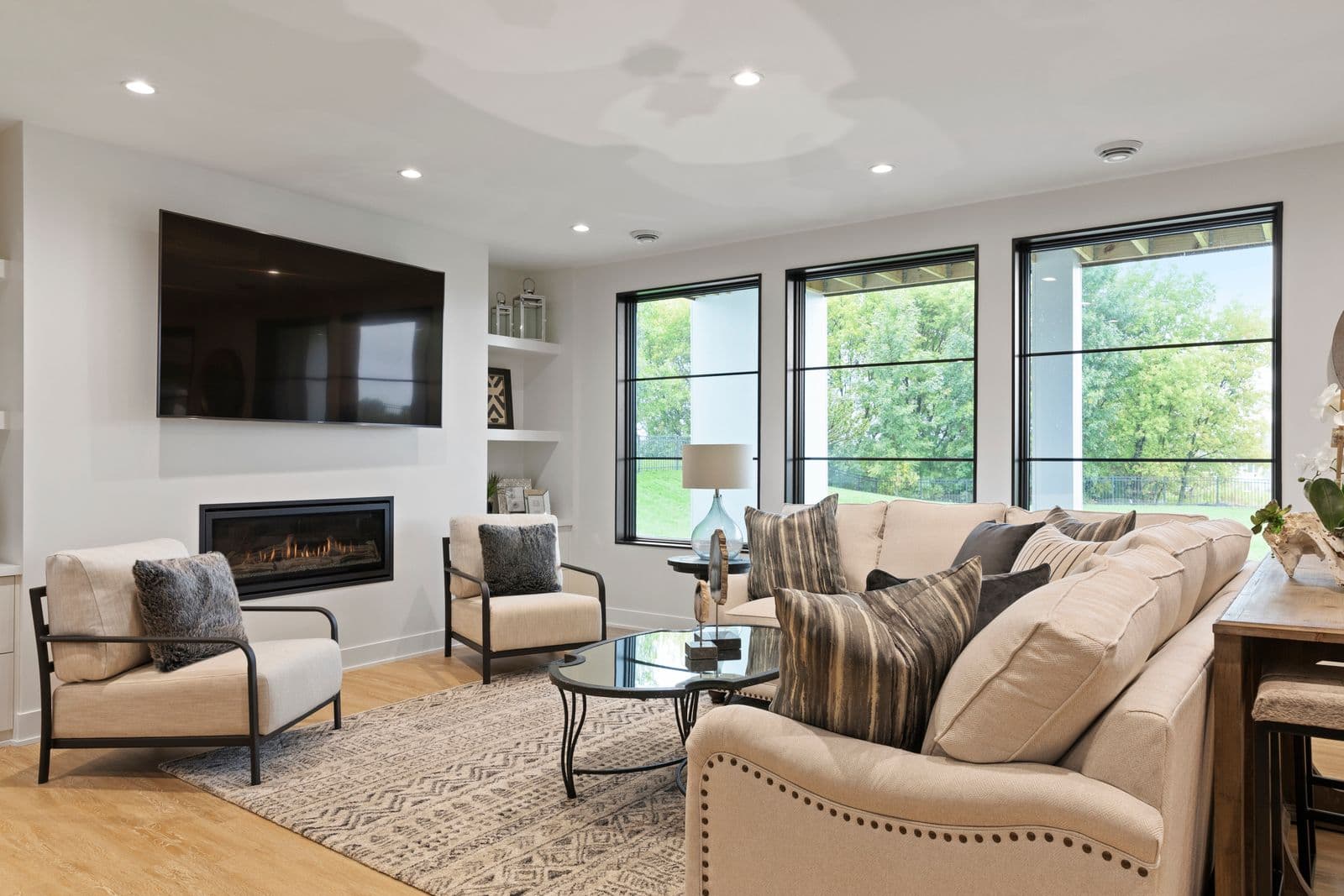 Contemporary family room with ceiling-mounted smart sensors and linear fireplace